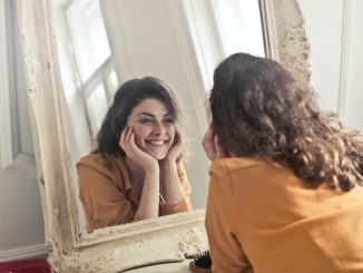 smiling in front of a mirror