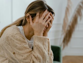 stressed woman with both hands on her head