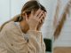 stressed woman with both hands on her head